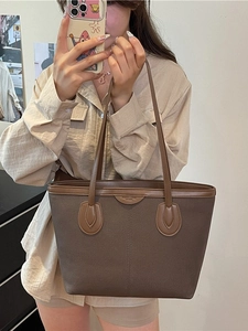 Brown frosted canvas tote bag with leather handles shown in a casual mirror selfie pose