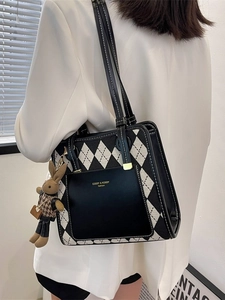 Chic black and white quilted tote bag with rabbit charm shown on a female model