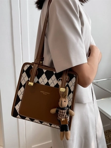 Chic black and white quilted shoulder bag with brown strap and cute bunny charm