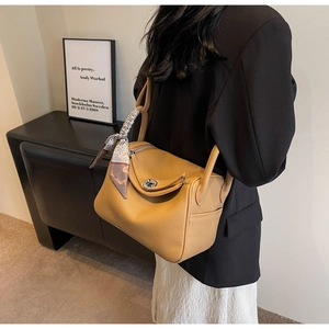 French vintage camel shoulder bag with a silk scarf handle wrap worn on the shoulder