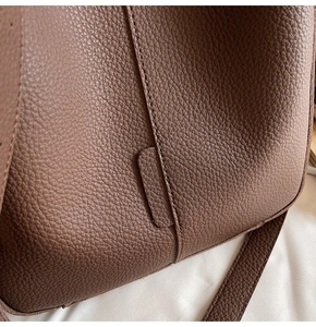 Macro shot of brown pebble grain leather texture with precise stitching and joint details