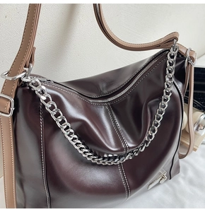 Détail du sac cabas marron foncé avec chaîne argentée et coutures blanches contrastées