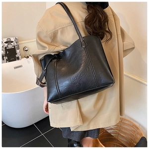 Détails du grand sac cabas noir en cuir brillant avec des bandoulières fines et souples