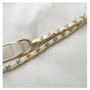Detail of woven white leather and gold chain shoulder strap with metallic D-ring buckle