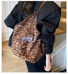 Close-up of leopard print tote bag with brown leather trim and glasses holder detail