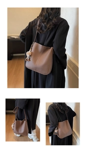 Macro detail of dark brown litchi grain leather bucket bag with cute plush pendant