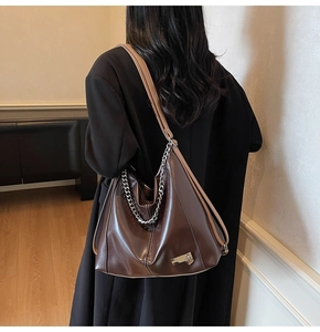 Détail du grand sac cabas en cuir marron foncé avec chaîne en métal argenté et bandoulière