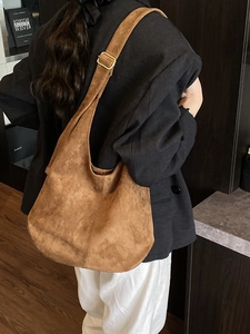 Retro brown suede canvas hobo tote bag with wide adjustable shoulder strap worn by model