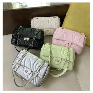 Detailed row of quilted flap bags in white, black, pink, green, and silver colors