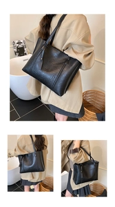 Close-up of the black large tote bag with textured faux leather and vertical stitching details