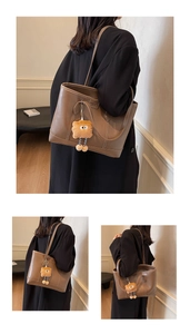 Détail du sac cabas en cuir marron foncé avec surpiqûres blanches et charme orange