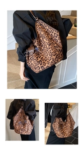Close-up of leopard print tote bag detailing a brown leather strap and accessory hook