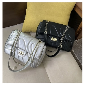 Detail of silver and black quilted crossbody bags with chain straps and metal twist locks