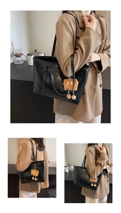 Détail du grand sac cabas en cuir noir avec surpiqûres blanches et charm toast