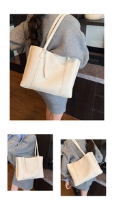 Détail du sac cabas vintage crème avec coutures verticales et breloque assortie
