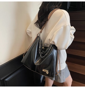 Détail du sac cabas en cuir noir avec chaîne argentée et pendentif en cœur