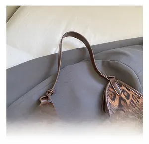 Close-up of leopard print faux fur tote with leather handle and fine stitching detail