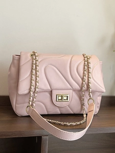 Quilted light pink underarm bag with gold chain strap and wave pattern faux leather