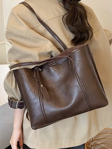 Grand sac cabas vintage marron foncé porté par un mannequin dans un style quotidien épuré
