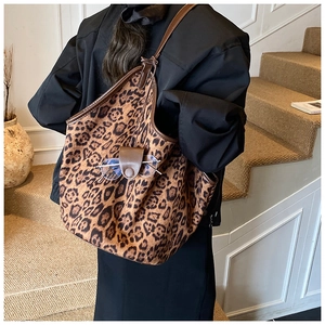 Detail of leopard print tote bag with leather strap and functional glasses holder pocket