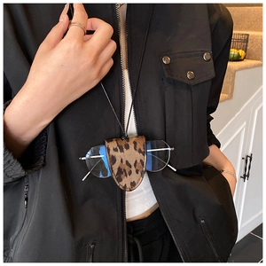 Close-up of leopard print glasses pouch on a model with minimalist neck strap