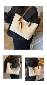 Detailed view of woven tote bag with brown leather straps and beaded tassel charm