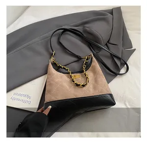Détails de sac beige en daim avec garniture en cuir noir et fermoir rotatif doré