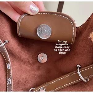 Detail of a brown suede tote bag featuring a strong magnetic closure for easy opening