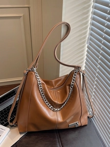 Sac cabas marron en similicuir avec chaîne argentée et breloque cœur dans un décor de bureau