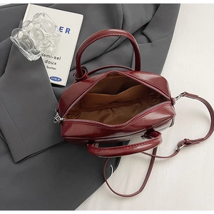 Close-up of the burgundy leather bag interior with brown lining and secure zip closure