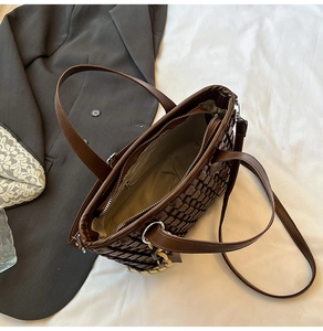 Macro view showing the spacious interior and woven texture of the dark brown tote bag