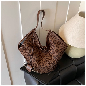 Macro detail of leopard print fabric texture and premium brown leather trim on tote bag