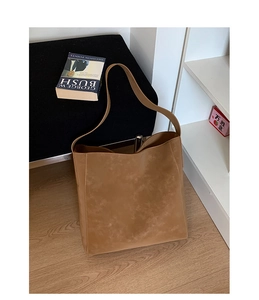 Dettaglio macro della borsa tote in pelle scamosciata opaca color cammello e cinturino