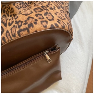 Detail of leopard print tote bag showing suede texture, leather trim and side zipper pocket
