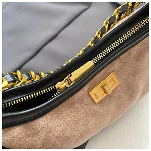 Dettaglio della borsa in pelle scamosciata trapuntata beige con finiture nere e oro