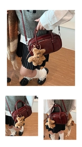 Dettaglio borsa bowling vintage in pelle rossa con ciondolo a forma di orso