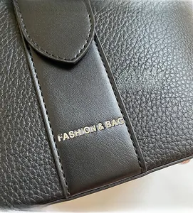 Detail of black lychee grain leather with Fashion & Bag silver metal logo accent