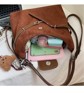Interior view of brown suede tote bag with tablet, umbrella, and cute bear pendant