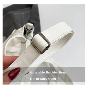 Detail of adjustable shoulder strap with silver metal buckle on soft white tote bag
