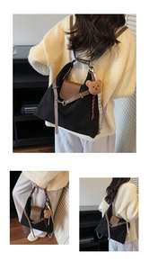 Detail of canvas hobo tote with leather flap, silver chain, and cute bear charm