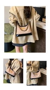 Détail du sac baguette bicolore avec daim beige, cuir noir et chaîne en métal doré