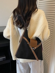 Large capacity black matte tote bag with brown trim shown on shoulder in daily lifestyle setting