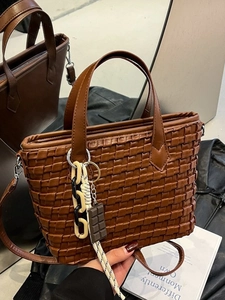 Vintage brown woven bucket handbag with crossbody strap and chocolate charm detail