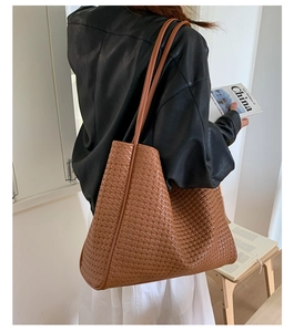 Brown woven tote bag shown on model for elegant daily commuting and casual style