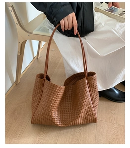 Detail shot of the fine texture on this large brown woven leather tote bag for women
