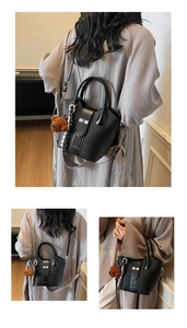 Detail of black lychee grain leather bucket bag with silk scarf and bear charm accessory