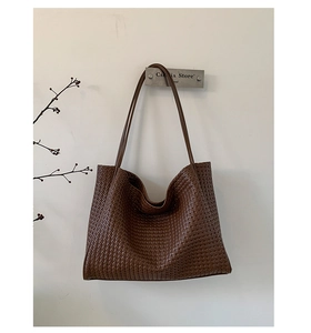 Macro detail of dark brown woven PU leather texture on minimalist large tote bag
