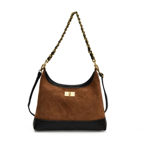 Sac hobo en daim marron avec matelassage et bandoulière chaîne dorée sur fond blanc