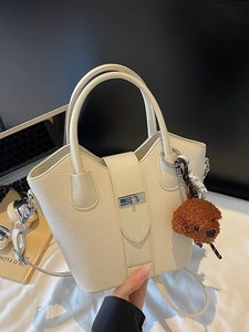 Minimalist cream white bucket bag with pebble leather and cute dog charm pendant