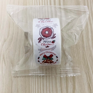 Close-up of Merry Christmas and Happy New Year kraft paper roll stickers on wood table